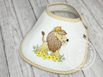 Babete branco com bordado de leão e flores amarelas com acabamento bege às bolinhas
