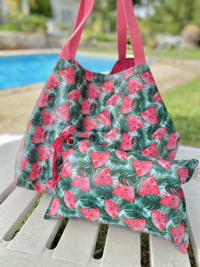 Bolsa e carteira com padrão de melancias e folhas em espreguiçadeira branca junto à piscina