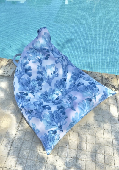 Almofada grande com padrão azul junto a piscina
