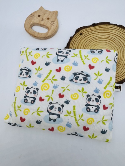 Manta branca com padrão de pandas e mordedor de madeira em forma de gato