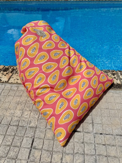 Almofada colorida com padrão de papaia junto a piscina