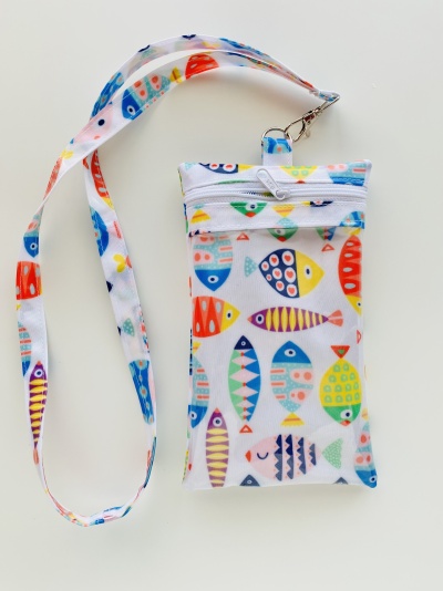 Bolsa pequena branca com padrão colorido de peixes e tira de pescoço combinando