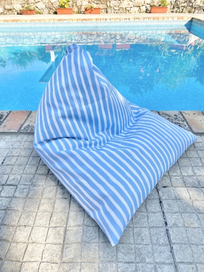pufe azul e branco em riscas ao lado de piscina