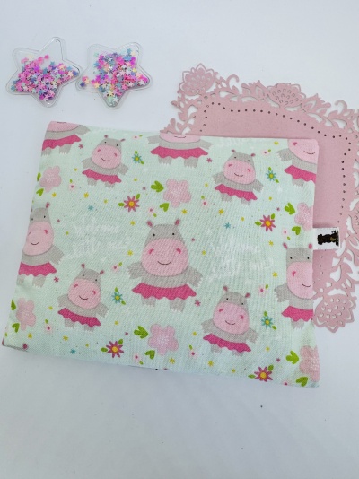 Fralda com padrão de hipopótamos cor-de-rosa, tapete rosa recortado e estrelas transparentes com miçangas.