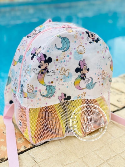 Mochila infantil branca com padrão de Minnie sereia e bolso em rede junto a piscina