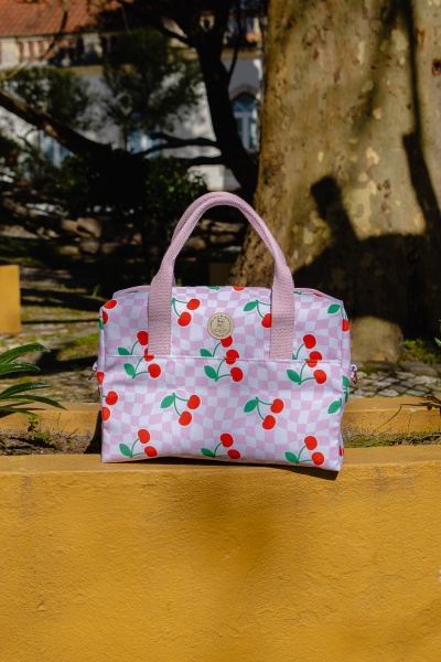 Mala rosa com padrão de cerejas e alças cor-de-rosa
