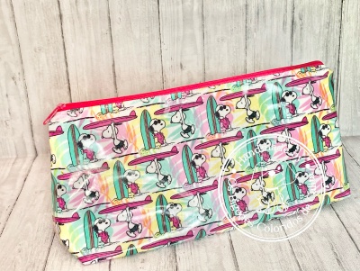 Estojo retangular colorido com padrão de Snoopy a surfar e fecho rosa