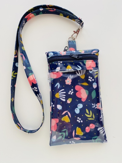 Bolsa pequena com padrão floral colorido em fundo azul e cordão para pendurar.