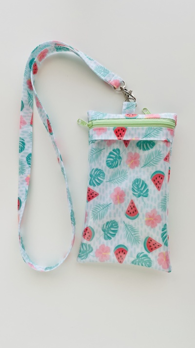 Bolsa pequena com padrão de folhas verdes, melancias e flores rosas com cordão ajustável.