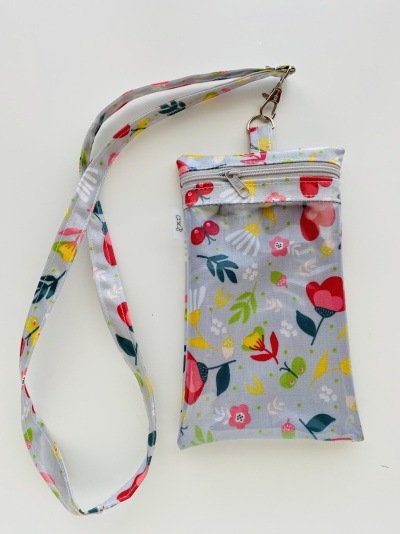 Bolsa pendente cinza claro com padrão floral colorido e fecho de correr branco