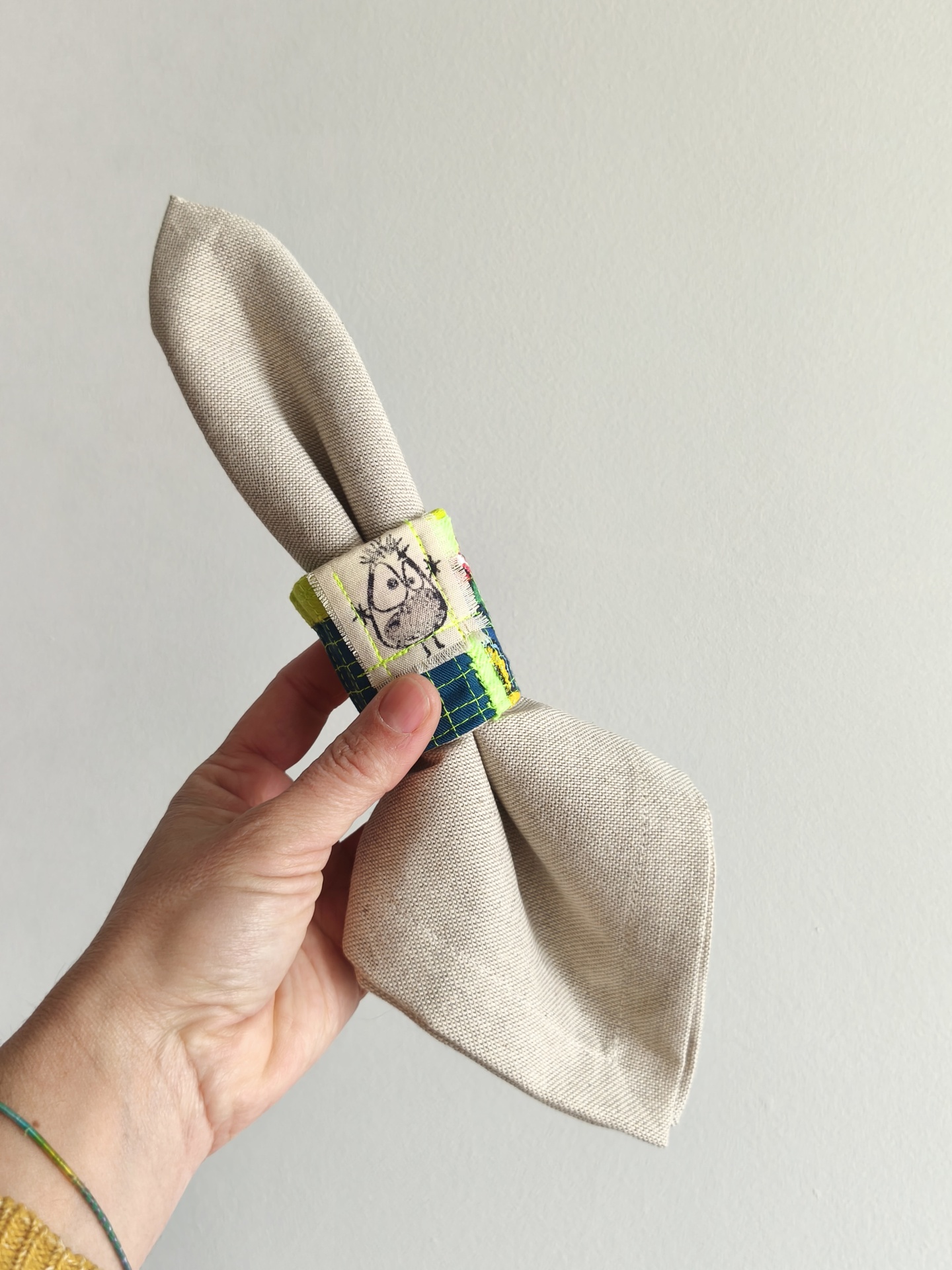 Argolas para guardanapos Guardanapo bege com suporte decorativo azul e amarelo com patch de rosto caricatural