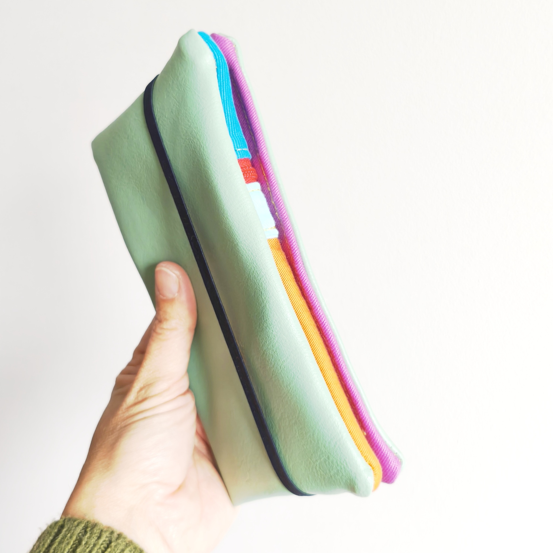 Carteiras porta-tudo! Estojo de lápis verde com fecho elástico preto e interior colorido