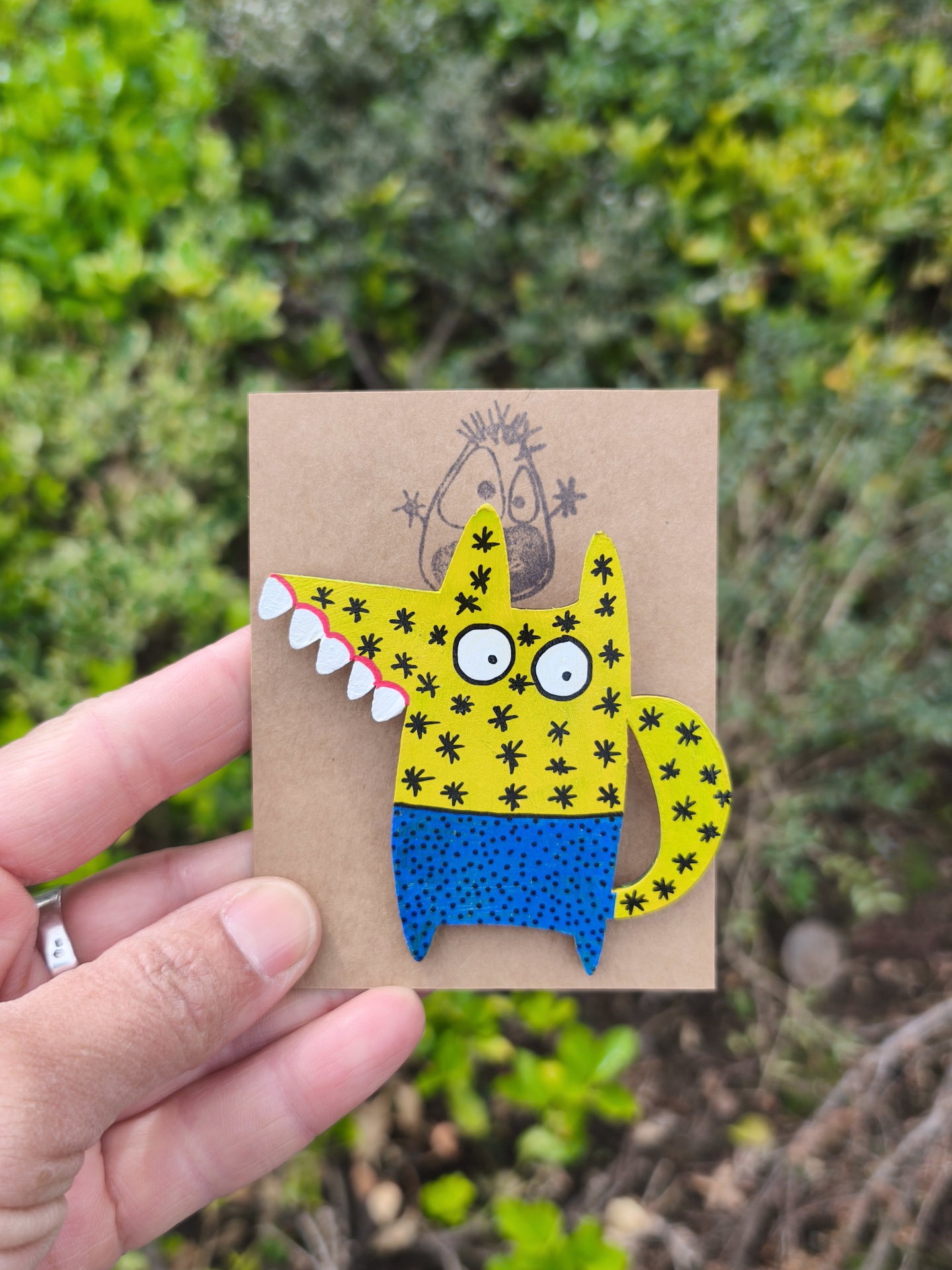 Alfinete lobo! Broche de madeira pintado à mão com personagem amarelo e azul segurado por mão