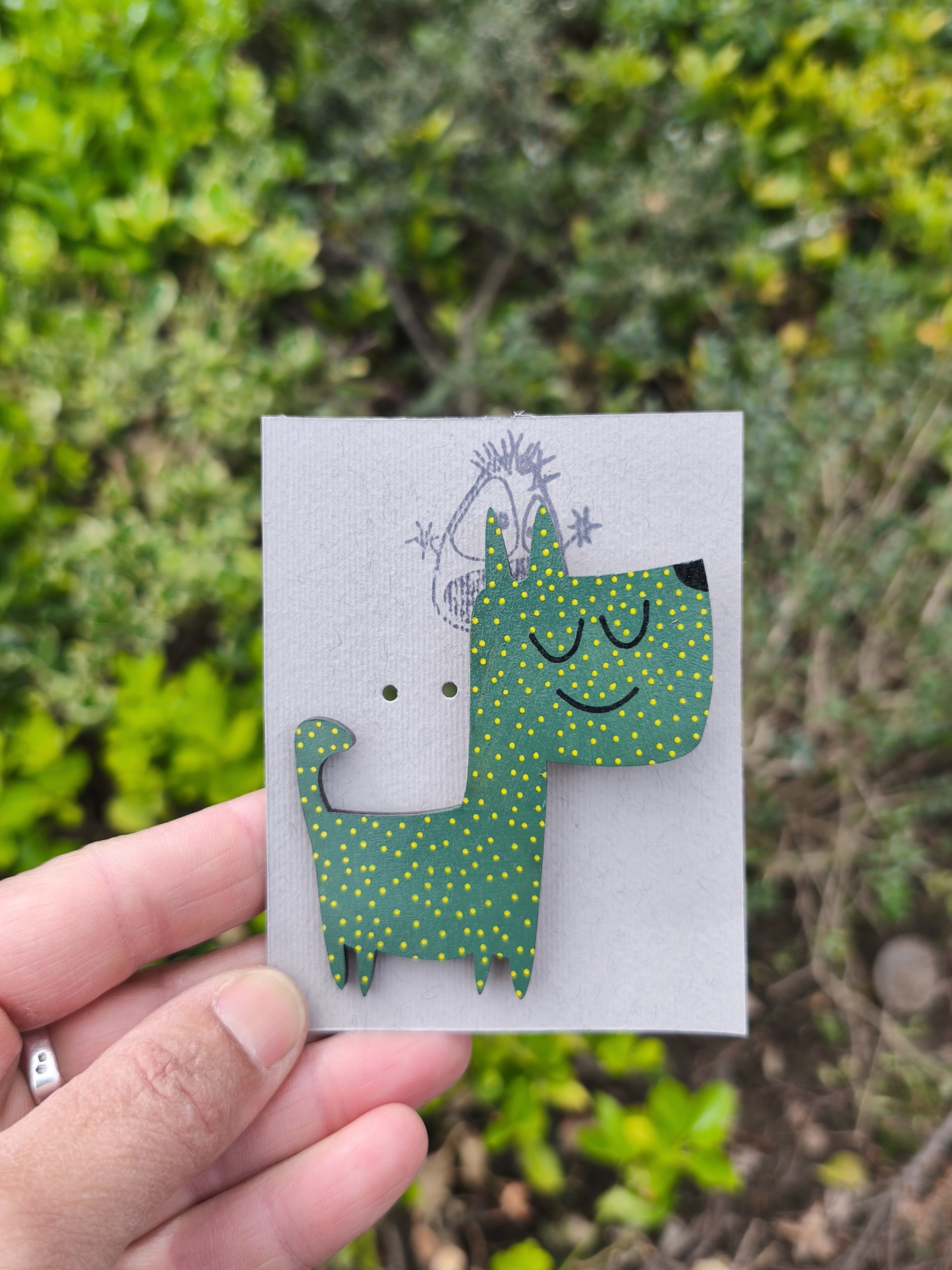 Alfinete cão #2! Figura de madeira em forma de cão verde com pontos amarelos e cartão cinzento com desenho de rosto