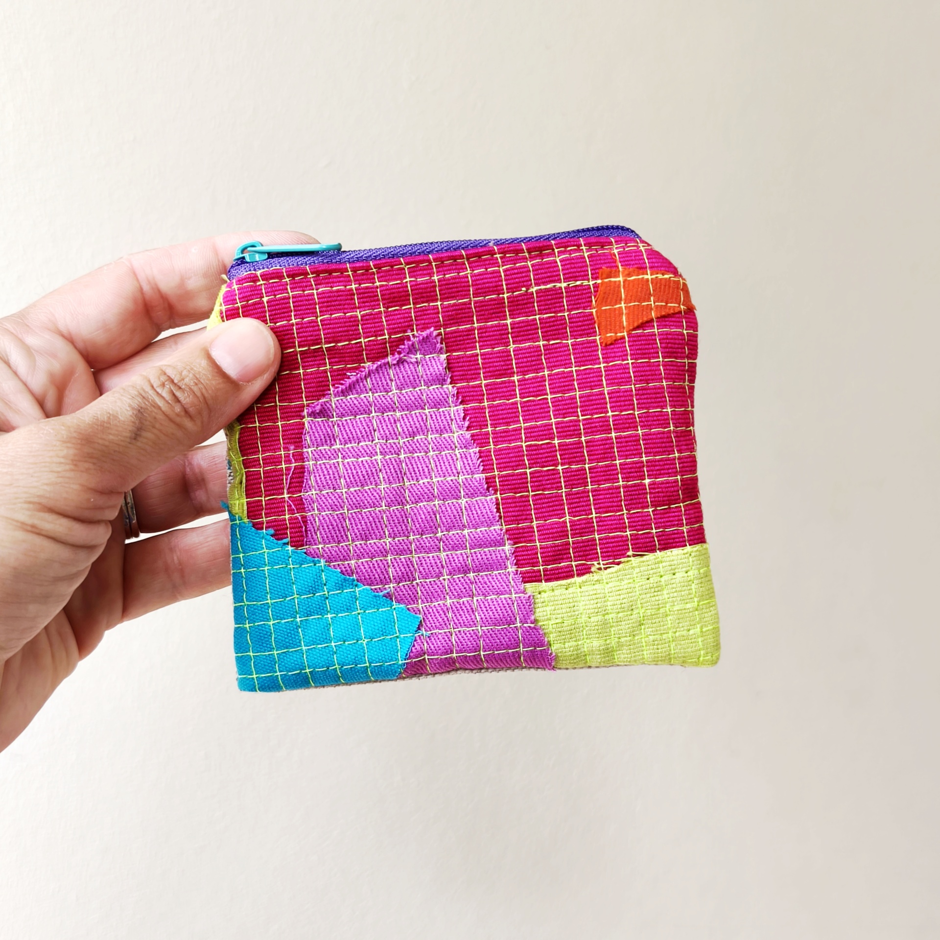Bolsa Trapo Carteira pequena colorida em tecido com padrão quadriculado amarelo sobre fundo rosa e fecho azul