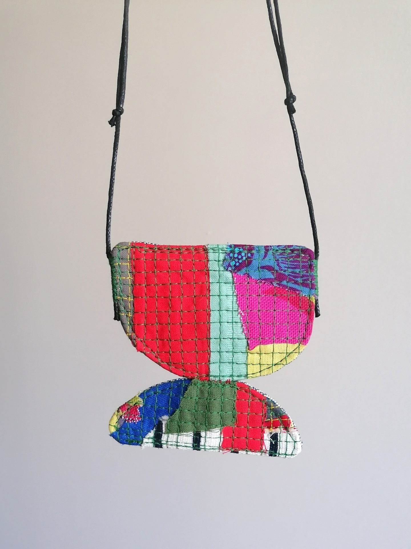 Colar Trapo Bolsa colorida em tecido com rede preta pendurada