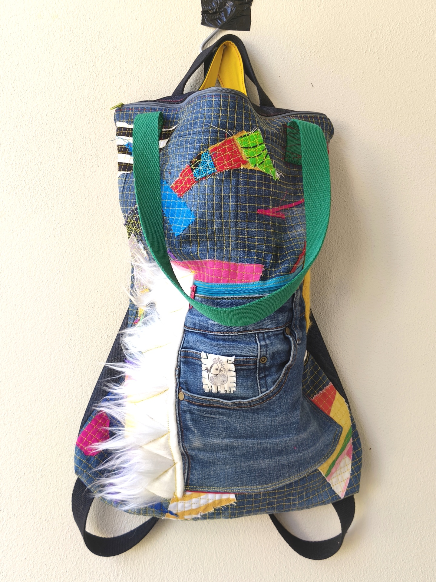 Bolsa/Mochila Mochila colorida de tecido com bolso jeans, detalhes de retalhos coloridos e franjas brancas.