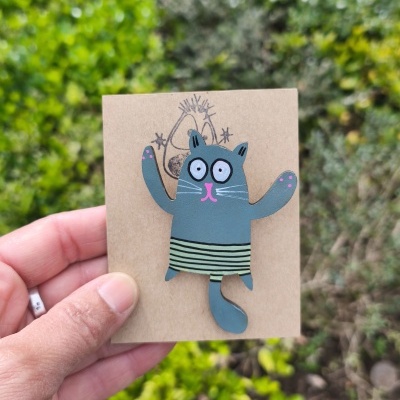 Broche metálico pintado à mão em forma de gato cinzento com saia riscada