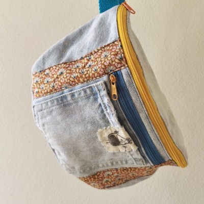Bolsa pequena de ganga com padrão floral e fechos coloridos