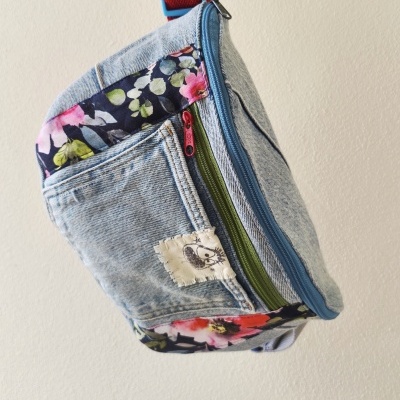 Pochete em tecido jeans com detalhes florais e fechos de correr coloridos