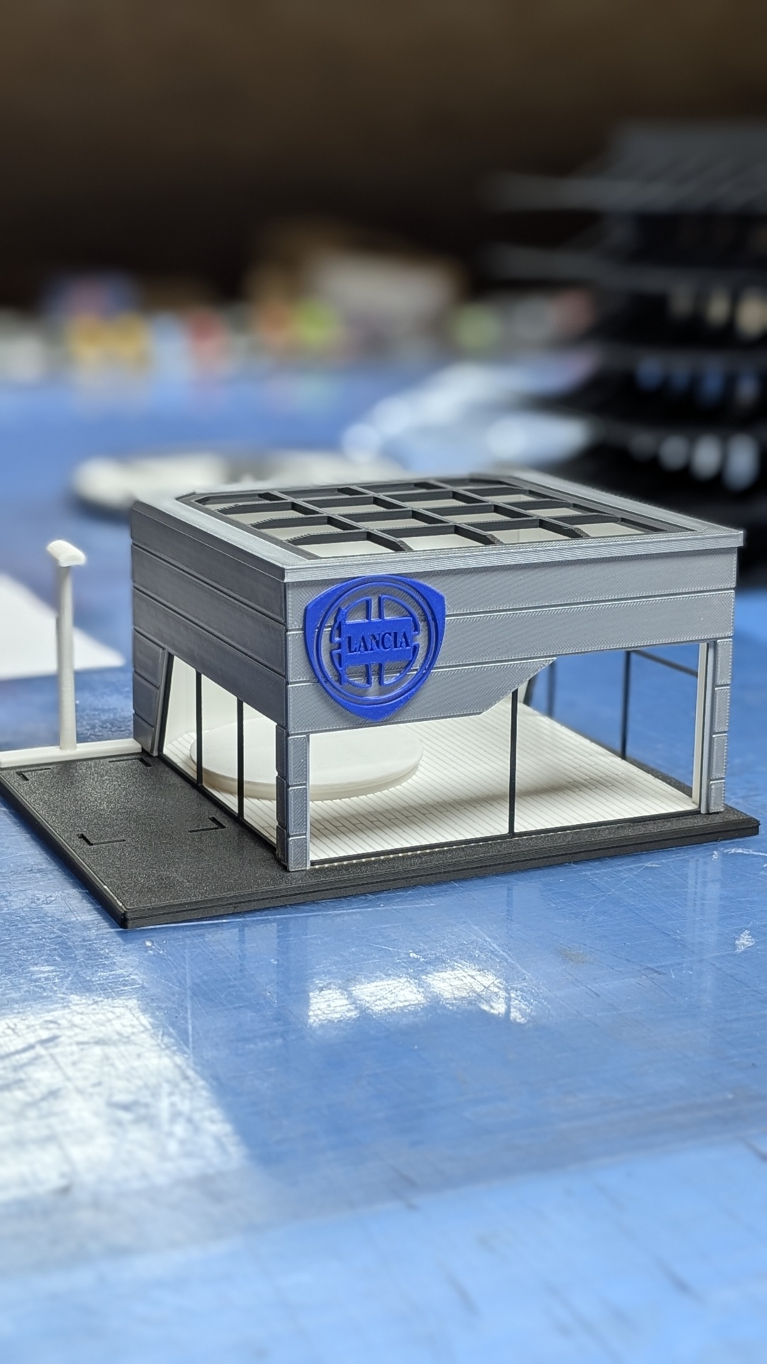 Miniatura de edifício com logótipo azul da LANCIA