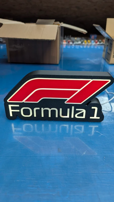 Objeto decorativo Formula 1 vermelho e branco em mesa azul