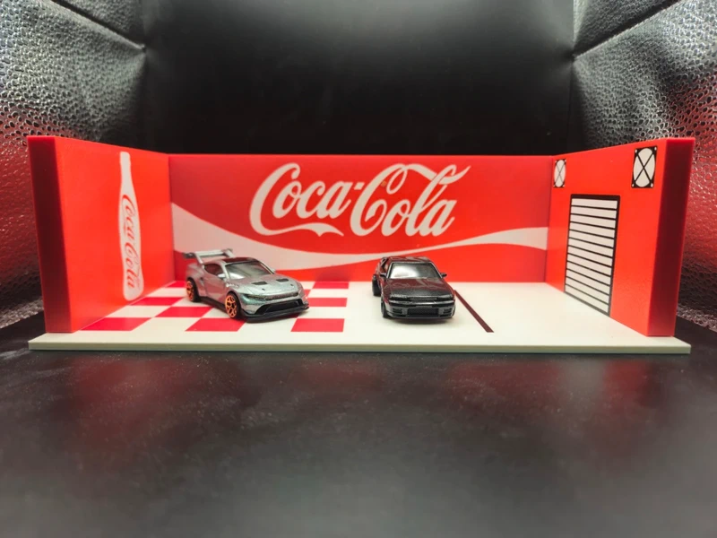 Miniatura de cenário com carros e logótipo Coca-Cola