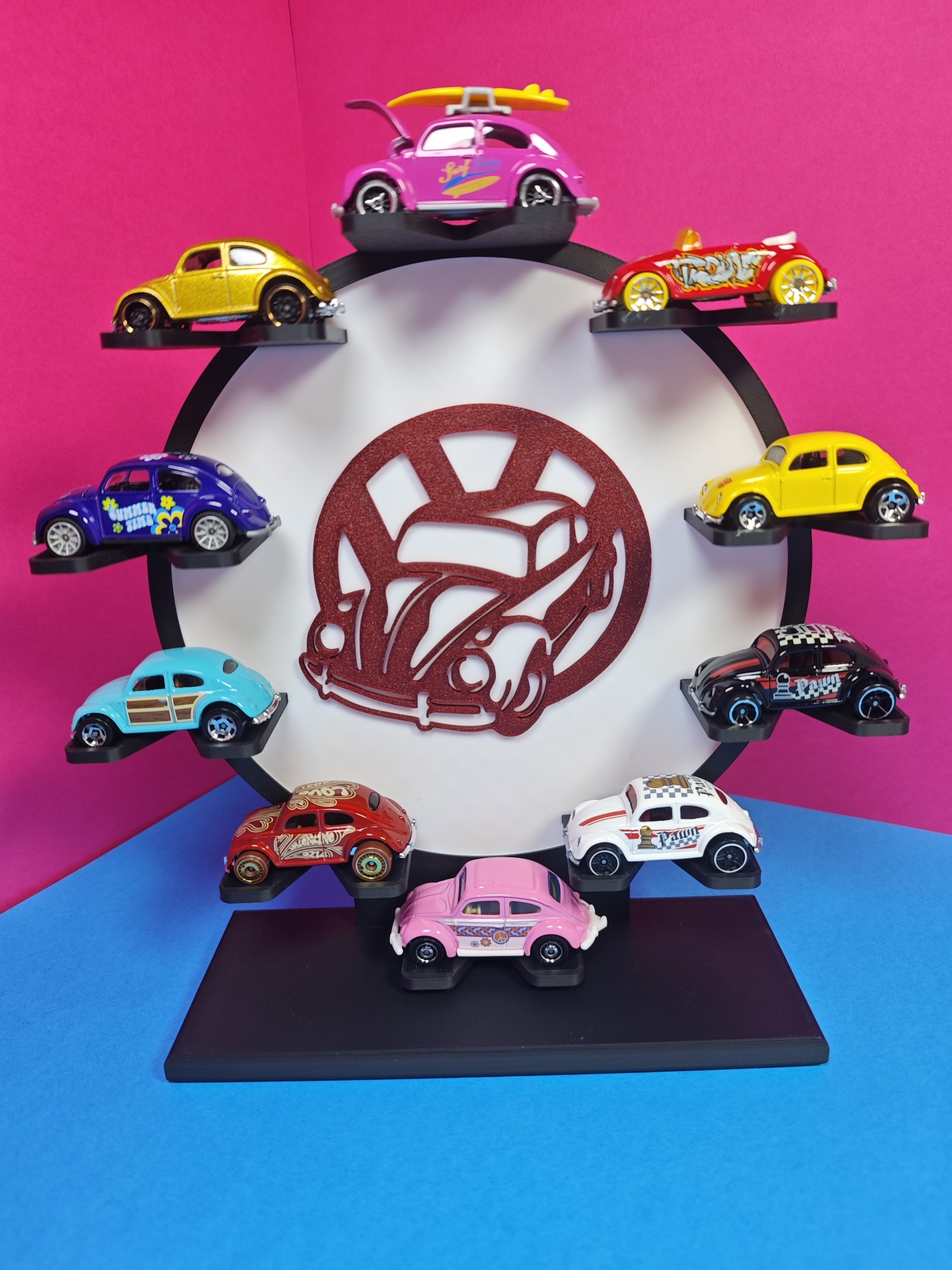 Coleção de carrinhos Volkswagen Beetle coloridos em suporte circular com logo central.