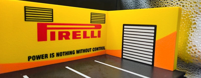 Cenário em miniatura com logótipo PIRELLI e texto em parede amarela