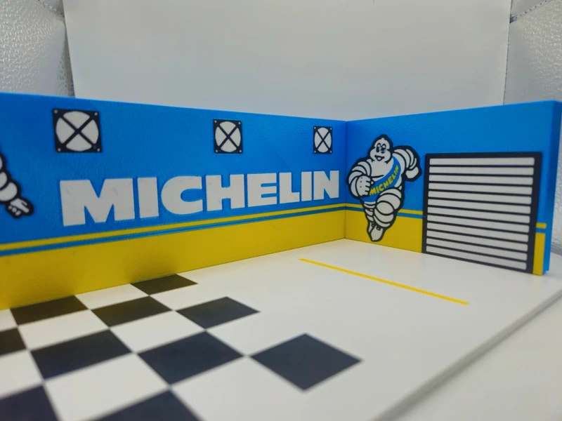 Miniatura de cenário de garagem com logo MICHELIN e boneco Michelin