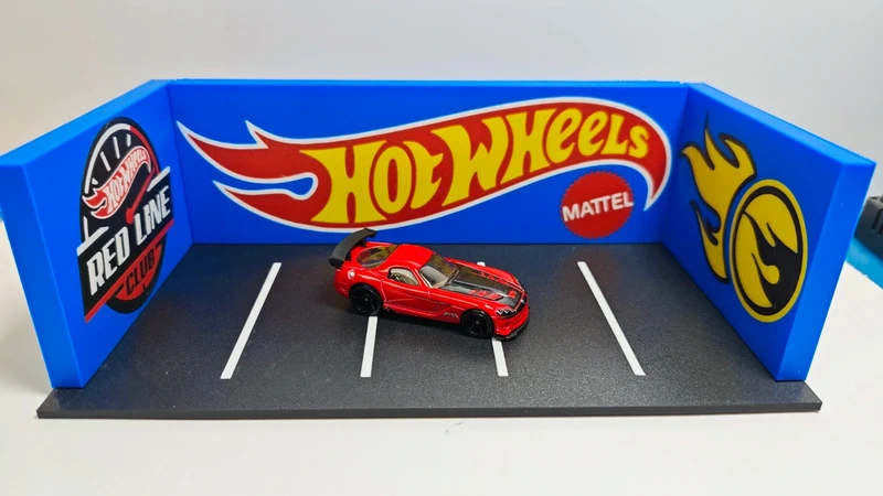 Miniatura de carro Hot Wheels vermelho em base de exposição com texto e painéis azuis