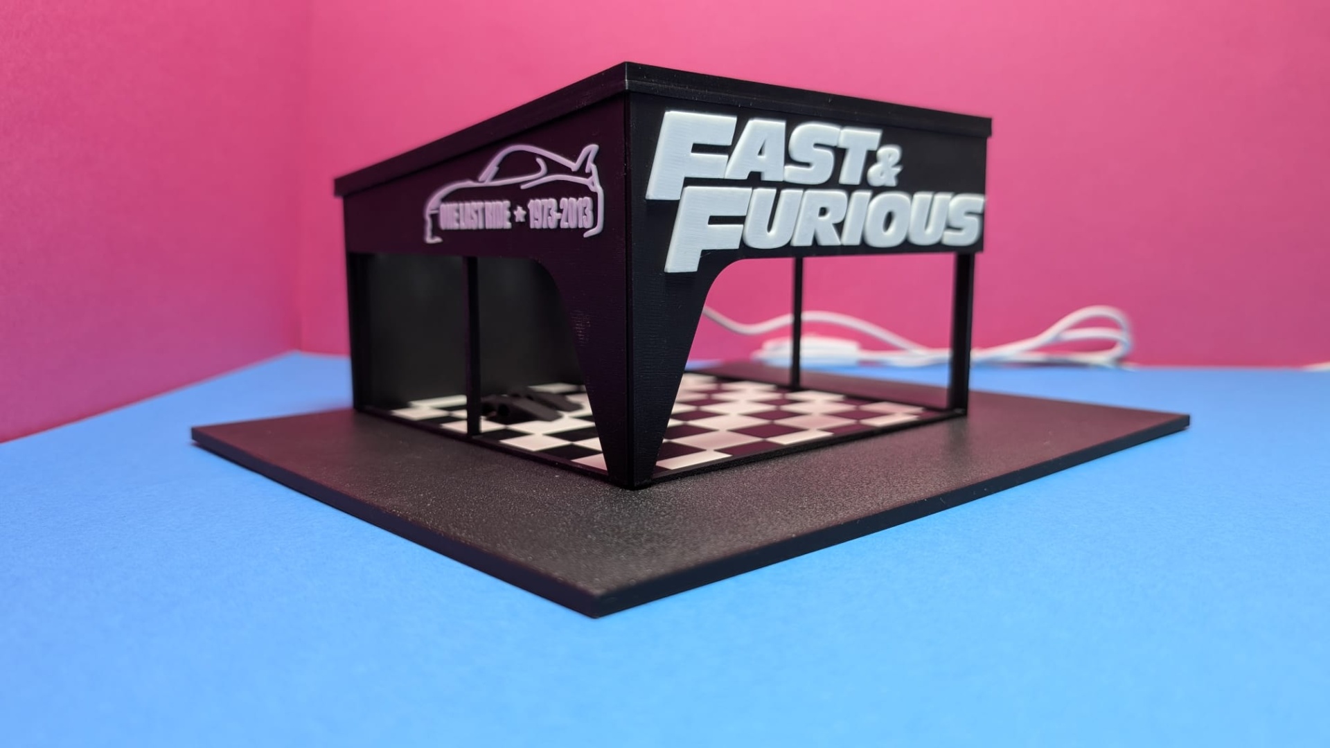 Modelo tridimensional preto com base quadrada e inscrições Fast & Furious