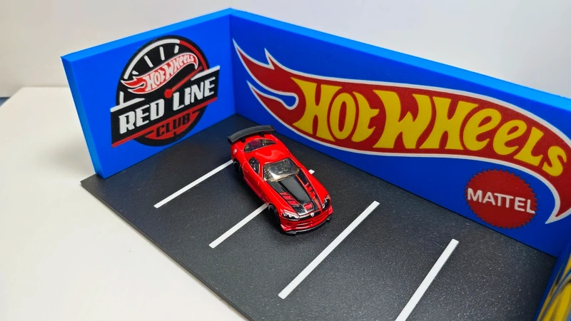 Miniatura de carro desportivo vermelho Hot Wheels num parque de estacionamento de brinquedo.