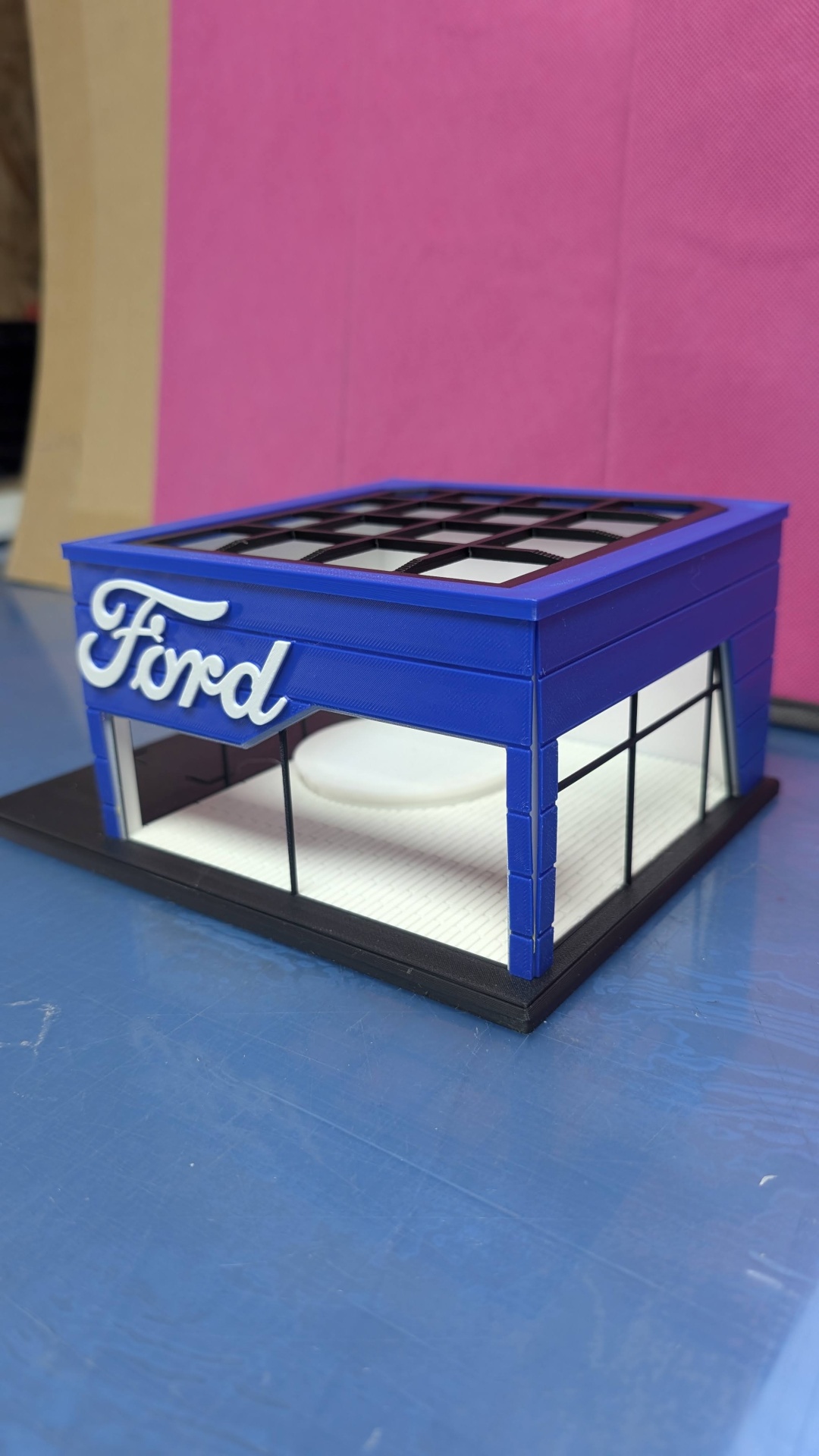 Miniatura de stand azul com janelas pretas e logo Ford em branco