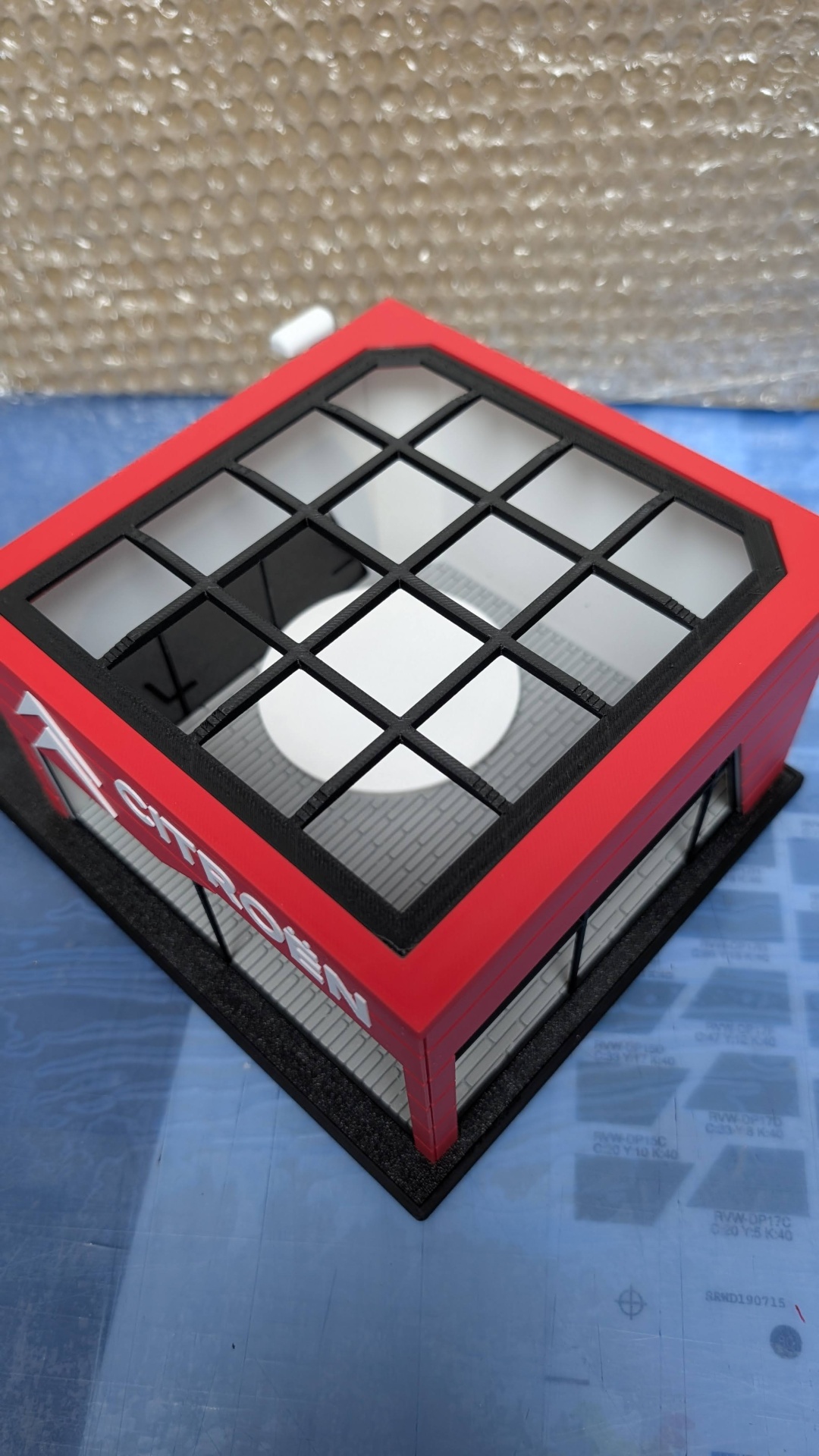 Miniatura de loja vermelha com rótulo CITROËN e topo em grelha preta