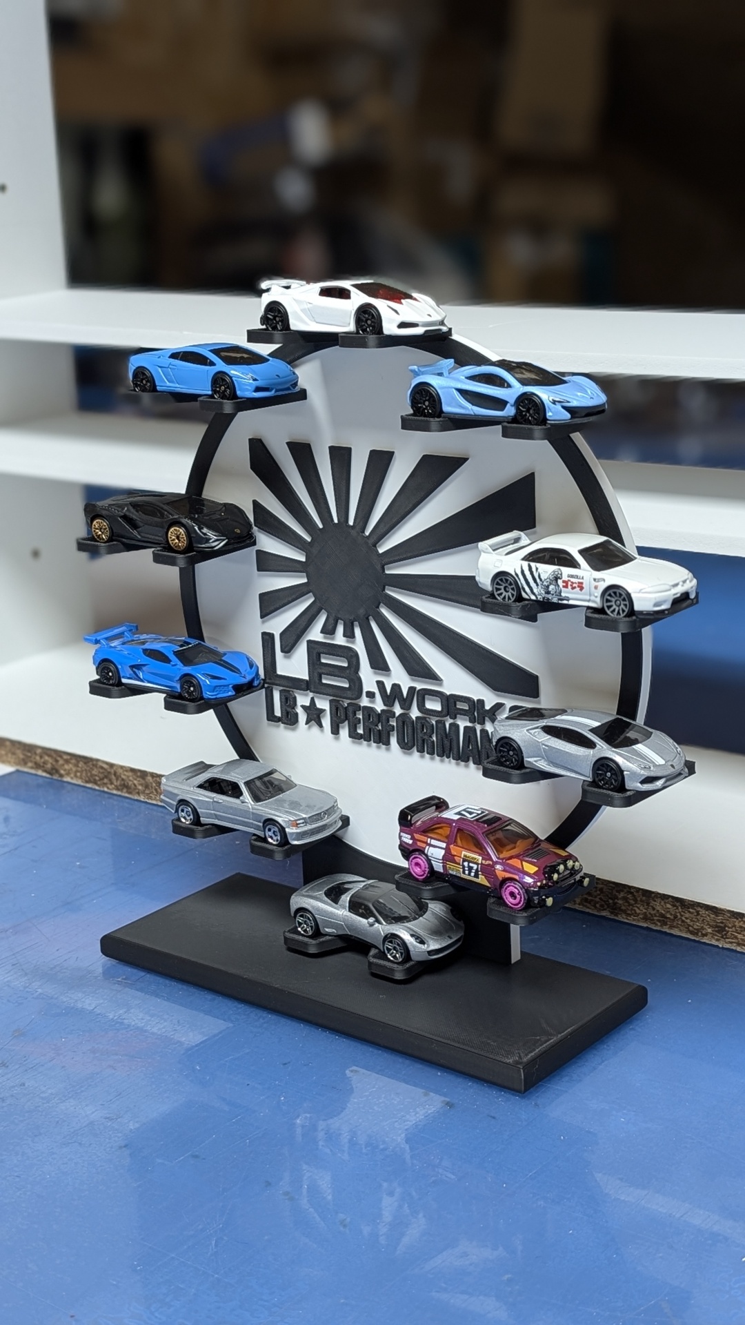 Miniaturas de carros de corrida em suporte preto com logo LB-WORKS LB PERFORMANCE