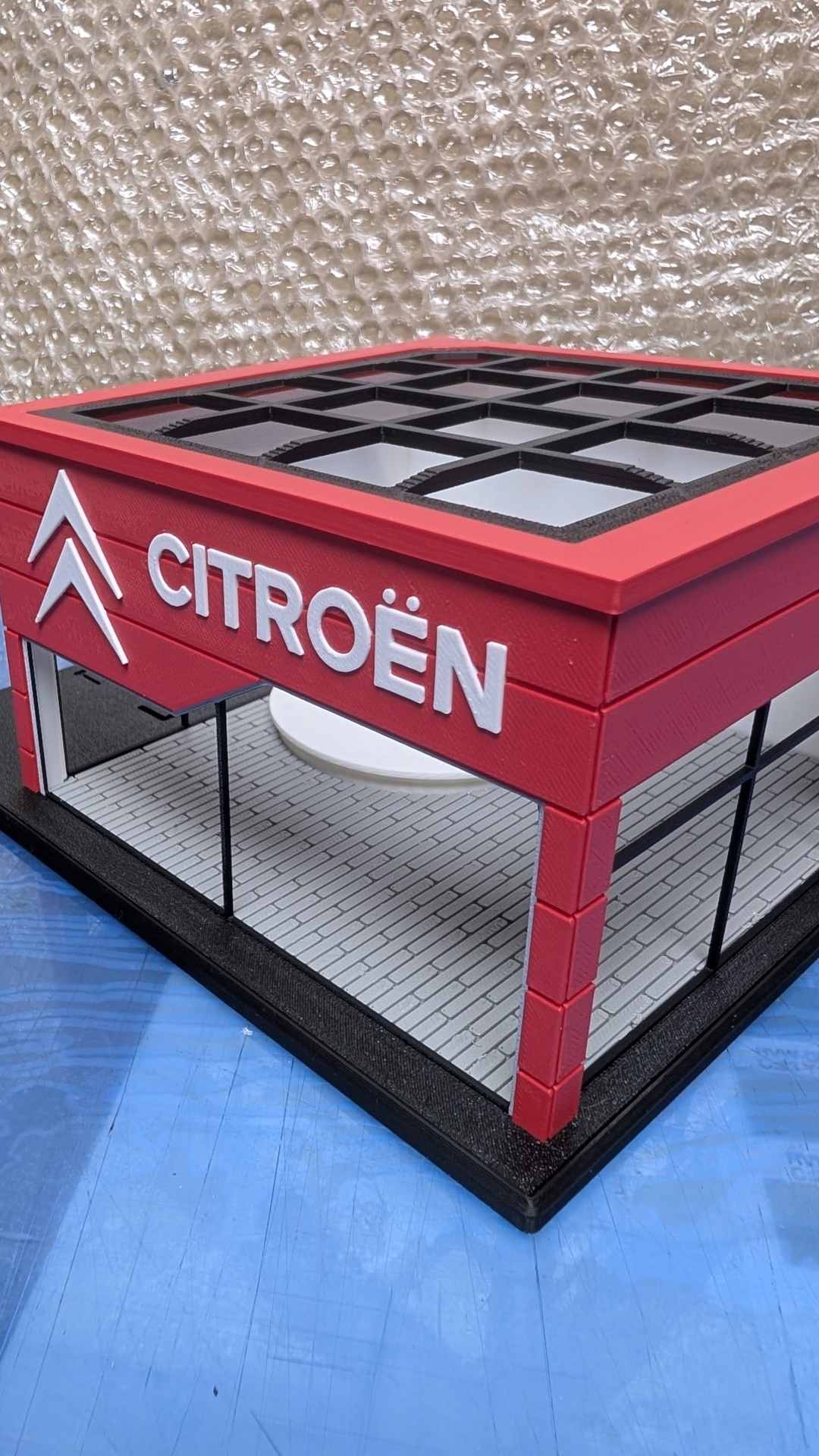 Modelo miniatura de loja Citroën vermelho e branco com janelas