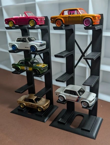 Carros de brinquedo coloridos em suportes plásticos pretos com fundo branco acolchoado