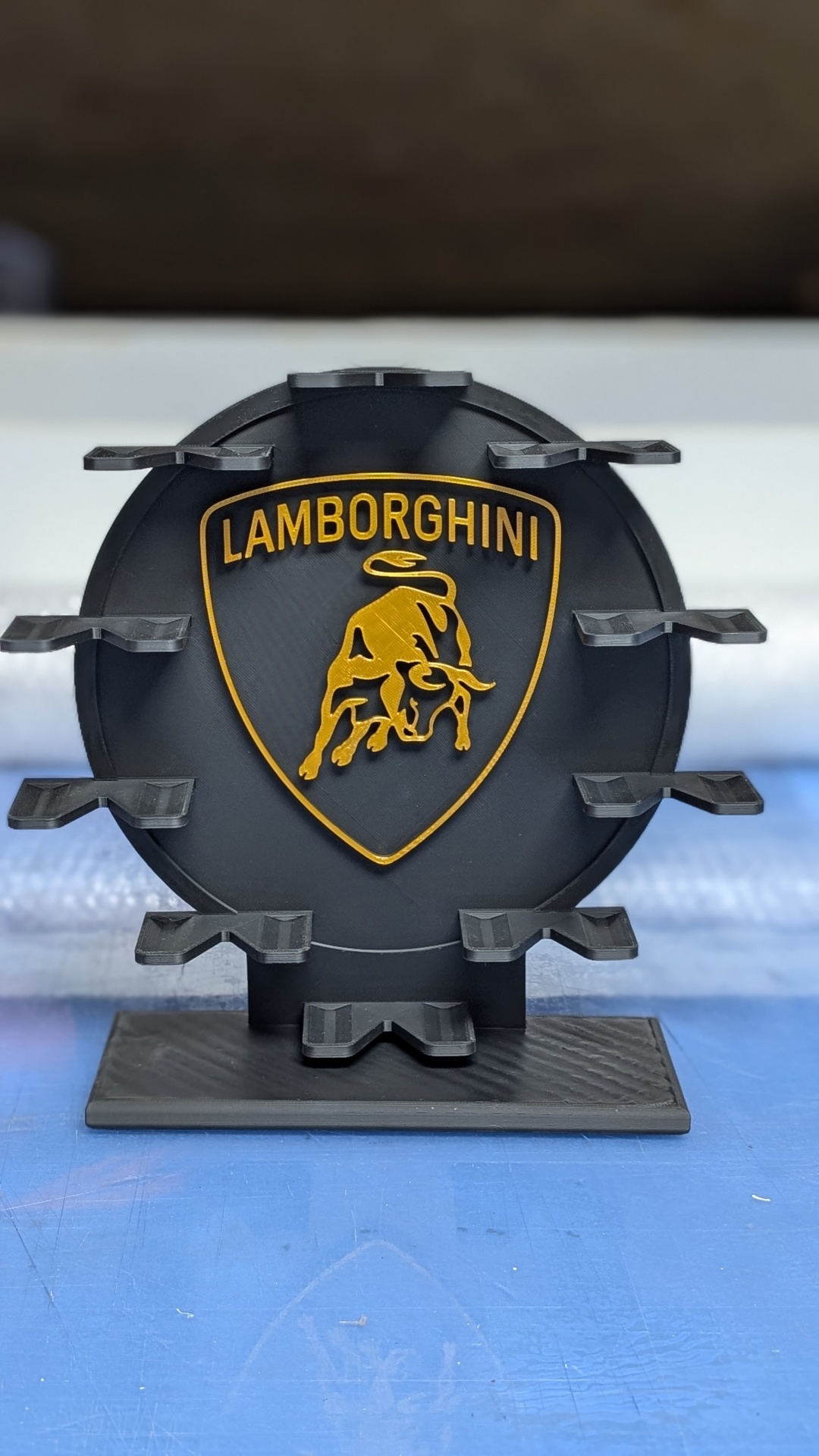 Suporte preto com emblema da Lamborghini dourado