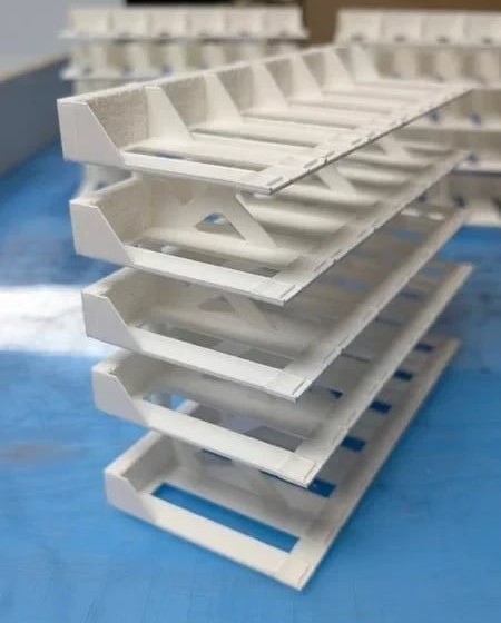Suportes organizadores de papel branco empilhados em superfície azul