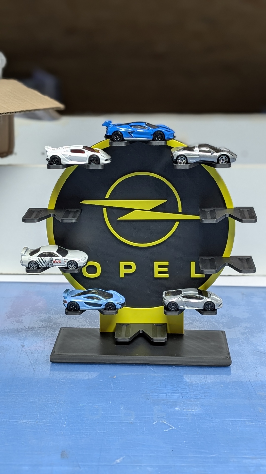 Suporte com miniaturas de carros desportivos e logótipo Opel