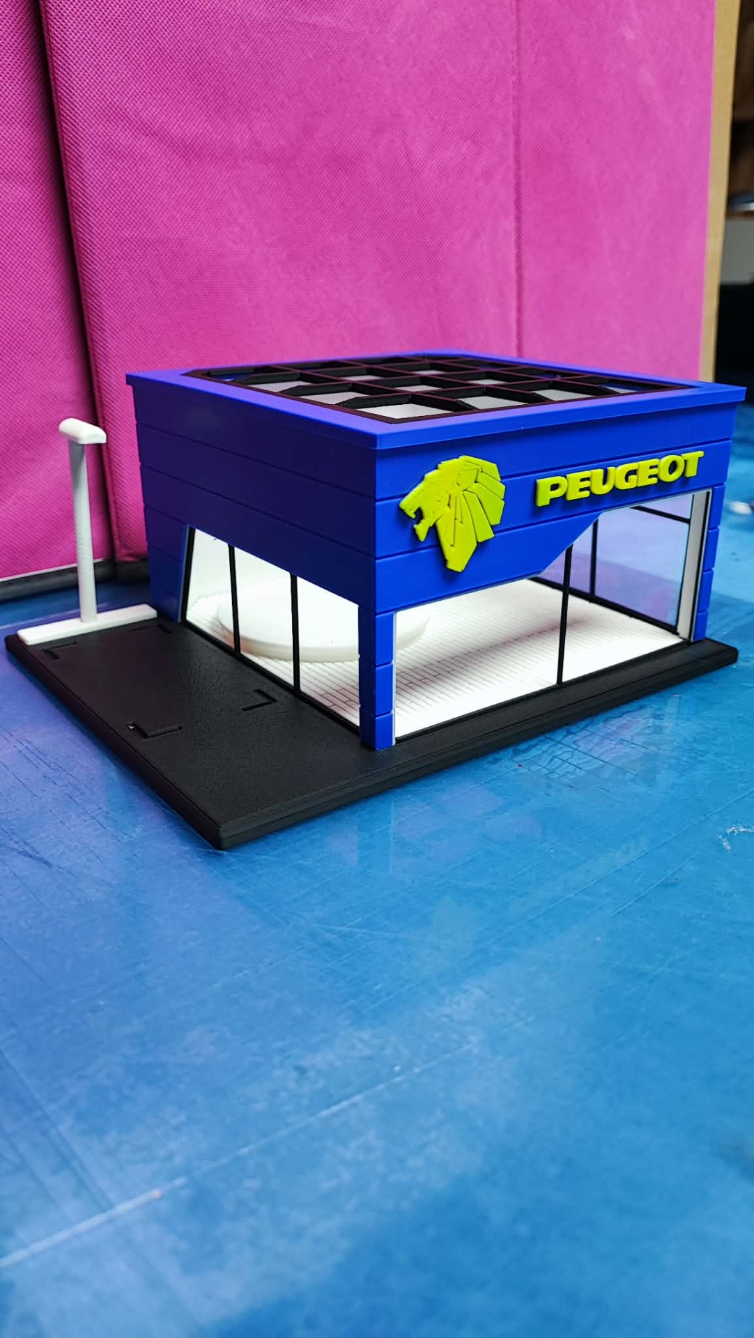 Miniatura de edifício Peugeot azul com logo amarelo