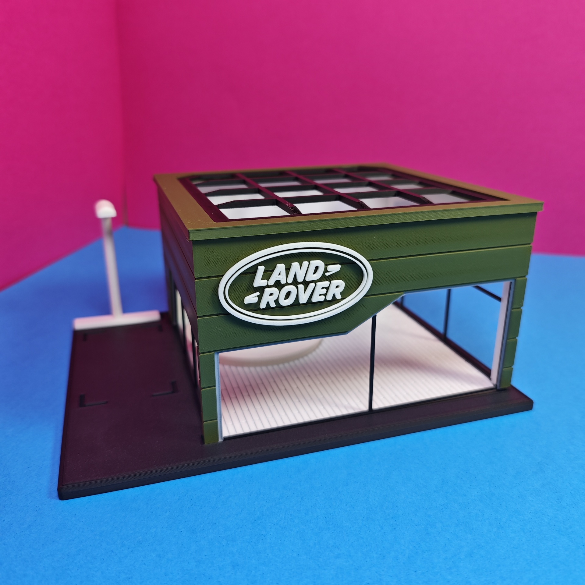 Modelo em miniatura de edifício LAND ROVER verde com janelas e base preta