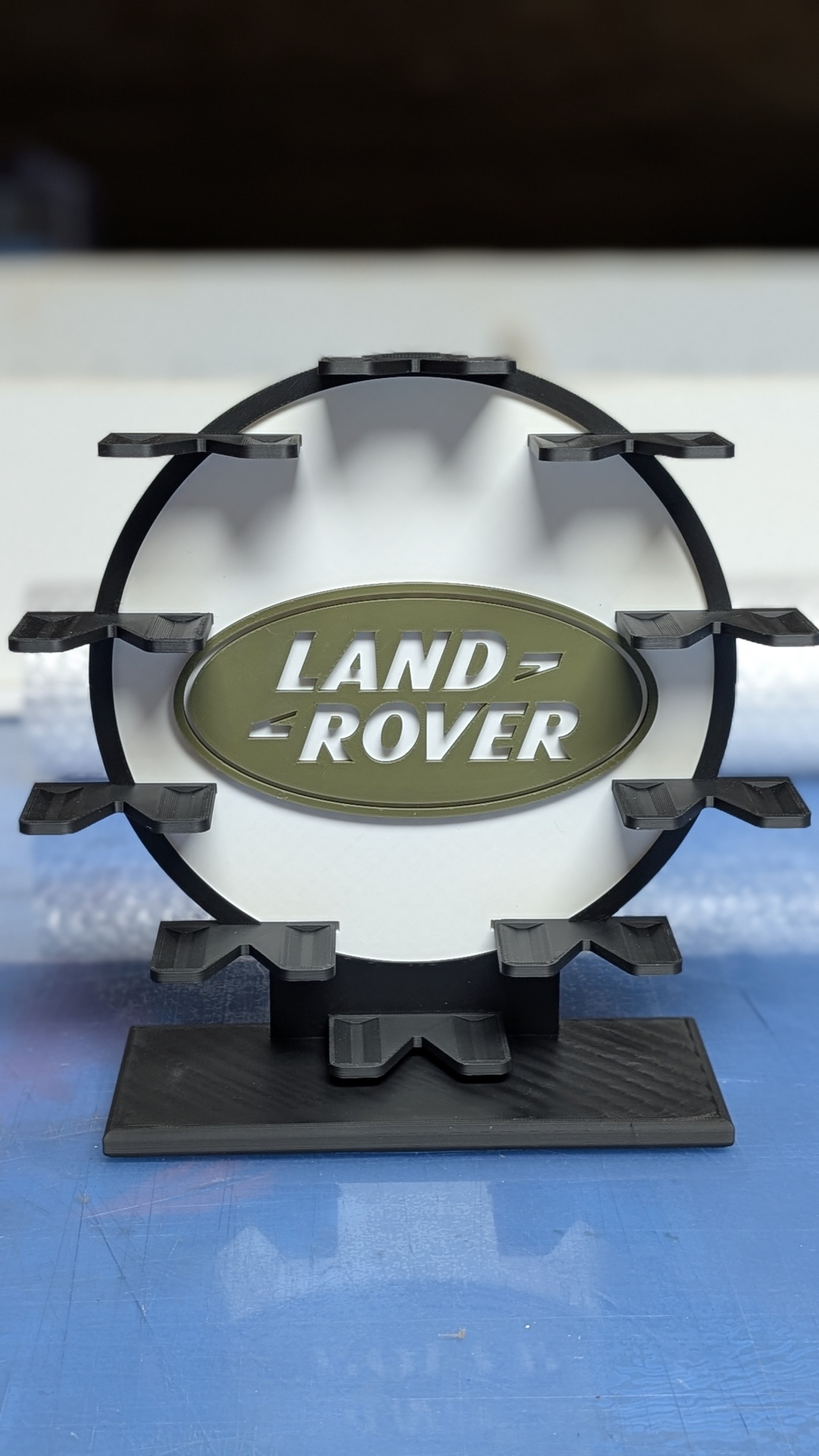 Suporte preto circular com emblema oval verde de Land Rover