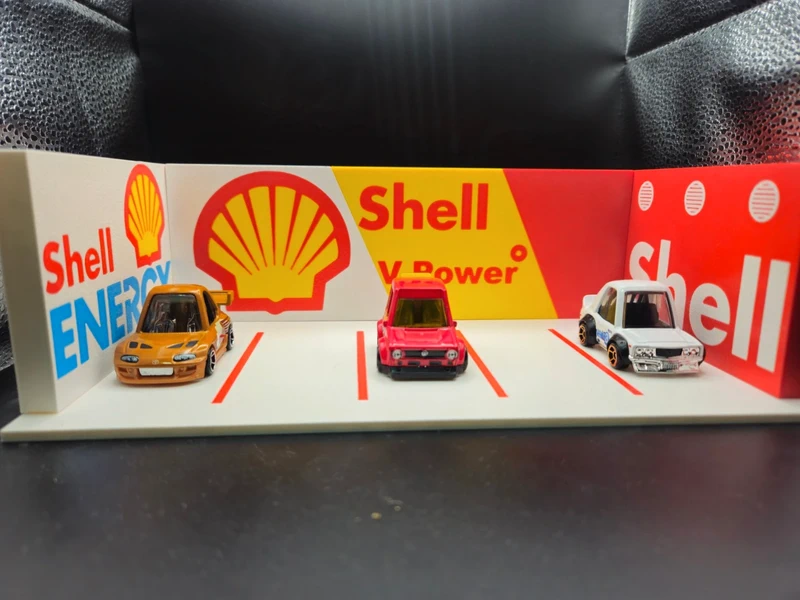 Estacionamento de carros em miniatura com logótipos da Shell nas paredes