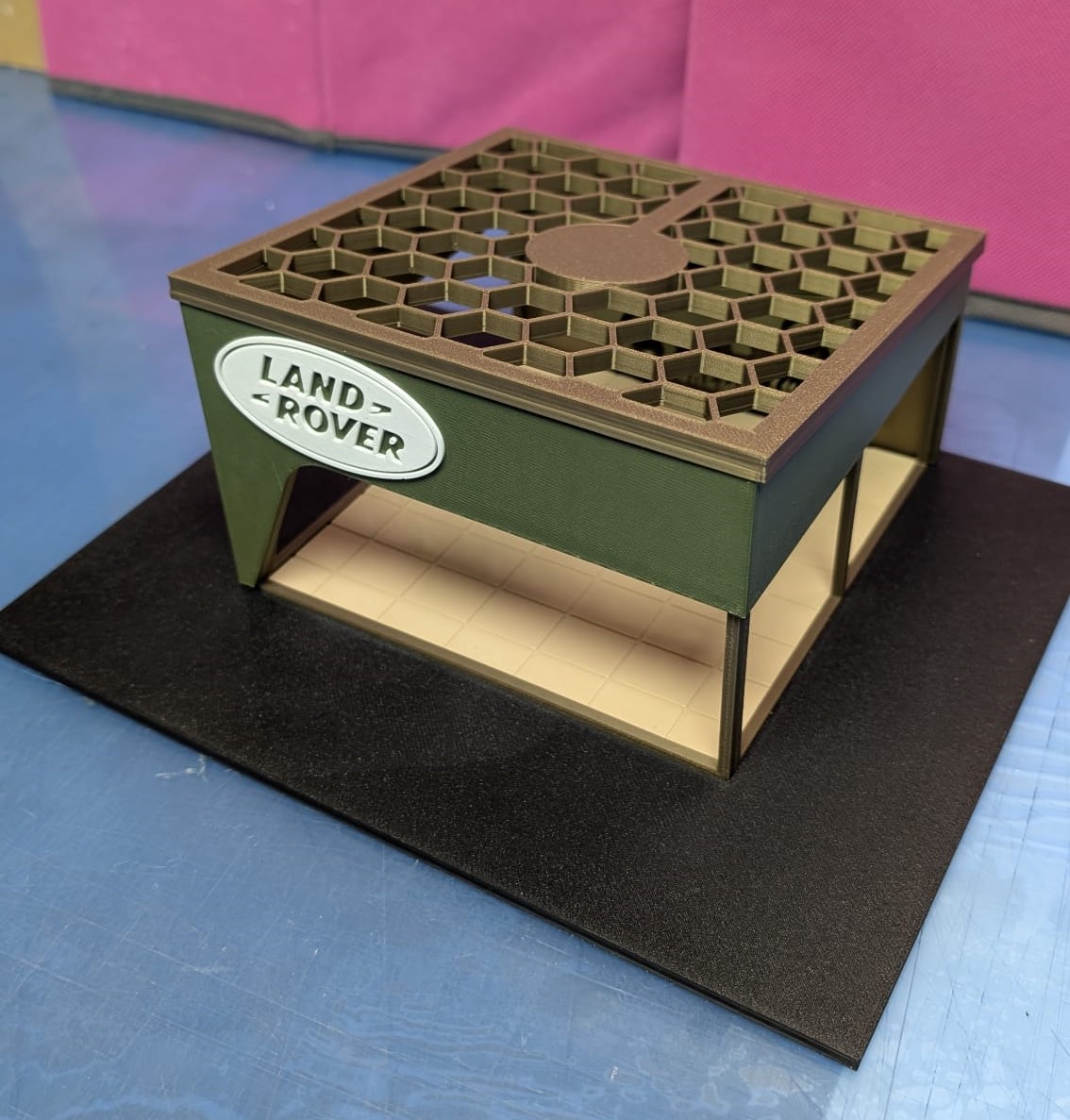 Miniatura de estrutura verde com topo hexagonal e placa LAND ROVER