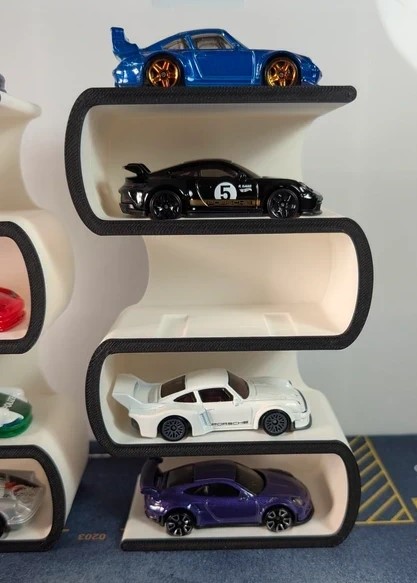 Carros miniatura expostos em prateleiras curvas brancas e pretas