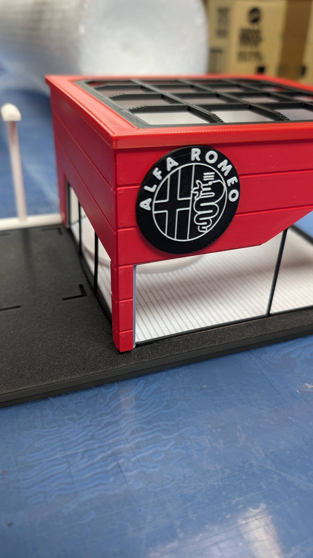 Miniatura de edifício vermelho com logótipo Alfa Romeo