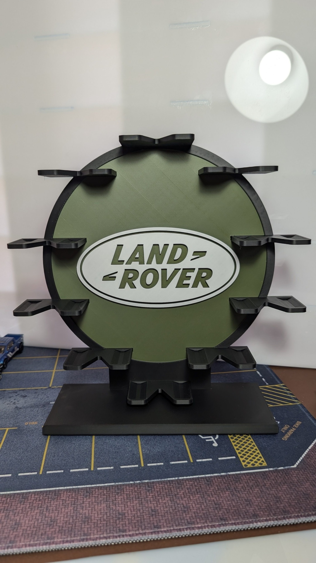 Suporte com logótipo Land Rover em verde e preto com várias saliências para apoio