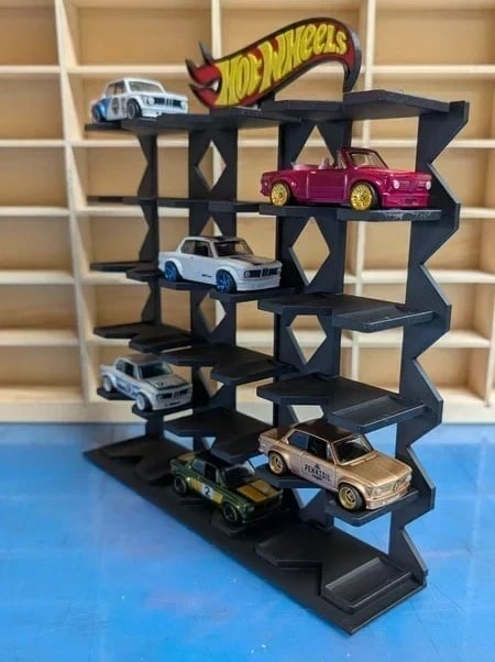 Expositor preto com carrinhos Hot Wheels coloridos e logótipo em ambiente com estantes de madeira